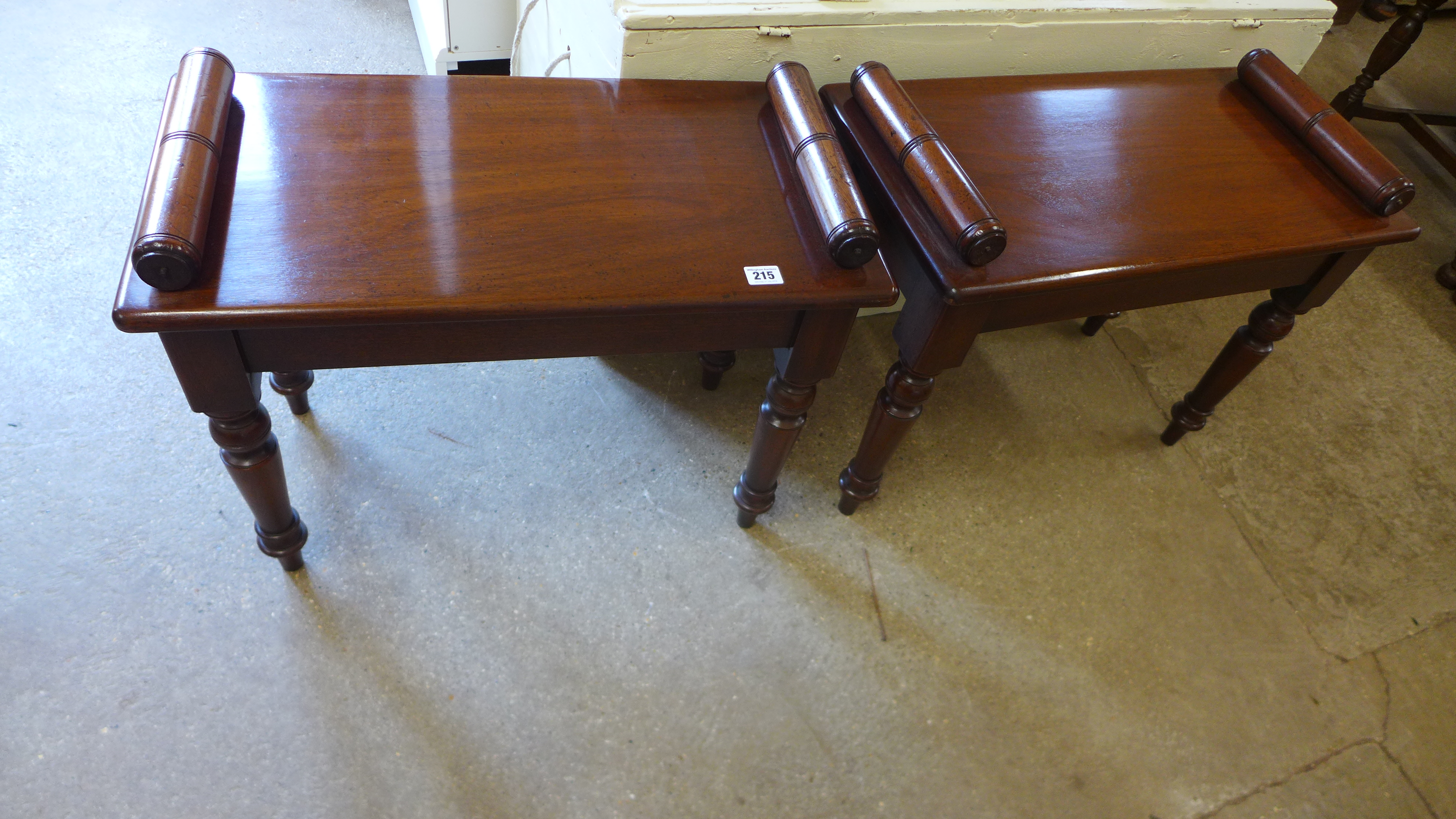 A pair of reproduction mahogany window seats with scroll ends raised on turned supports - 64cm x