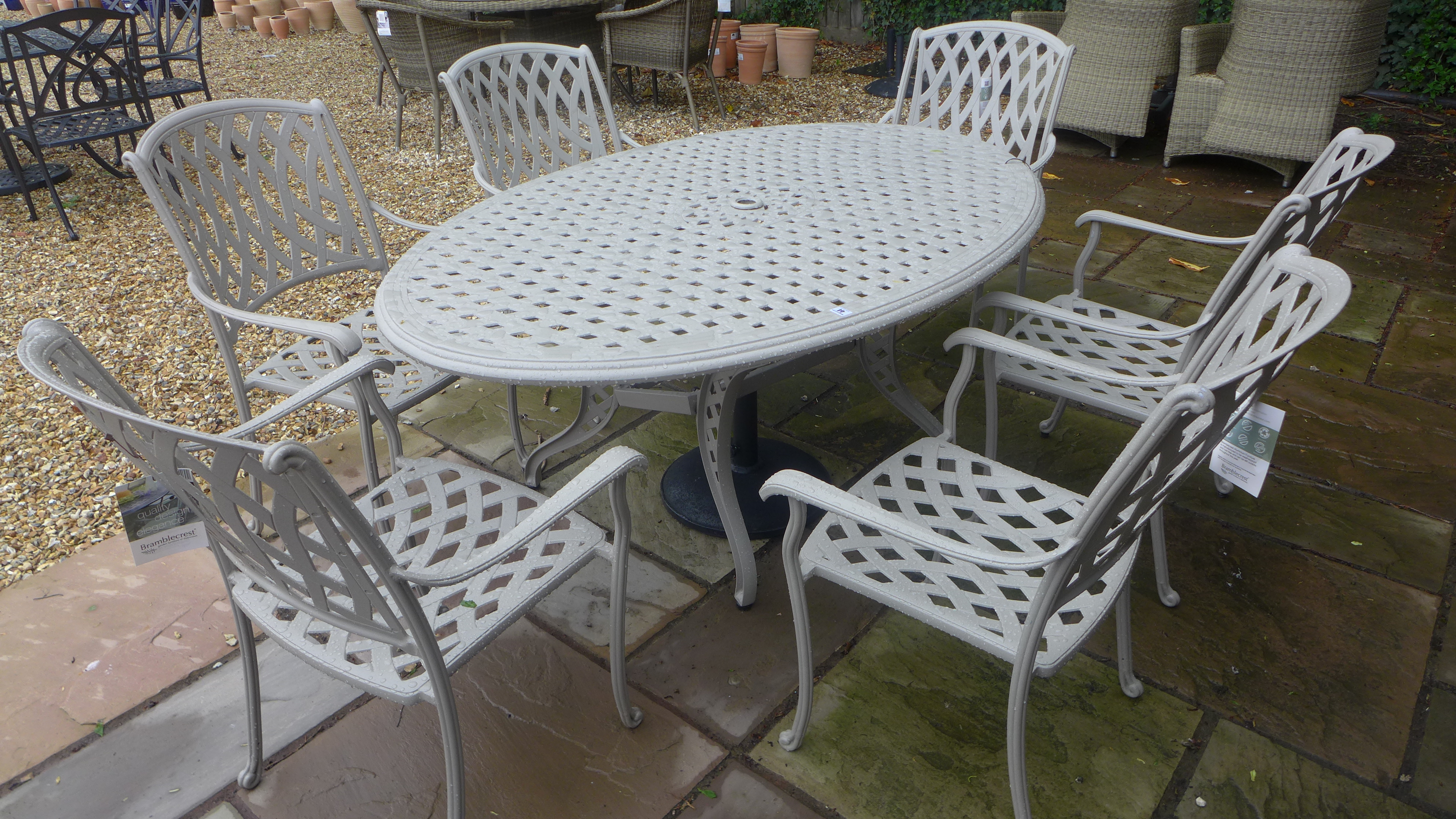 A Bramblecrest Roma stone table and 6 chairs - damage to one chair and the undertier table base