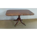 An early 19th century rosewood banded mahogany breakfast table - the rectangular snap top on turned