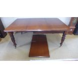 An early 19th century mahogany pull out dining table with two extra leaves on acanthus carved