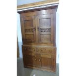 An 18th century oak food cupboard with a two door top above a two drawer two door base with