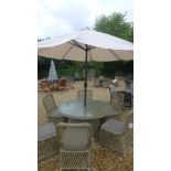 A Bramblecrest Ancona circular table with six chairs including cushions and a parasol and base some