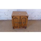 An early 20th century oak smokers cabinet with three internal doors