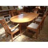 A modern Ercol light oak extending dining table with six chairs including two carvers -