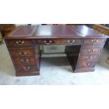 A modern nine drawer mahogany desk with a leather inset top - Width 158cm x Depth 88cm x Height