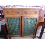 A 19th century mahogany cabinet with two drawers above two grillwork doors with material lining