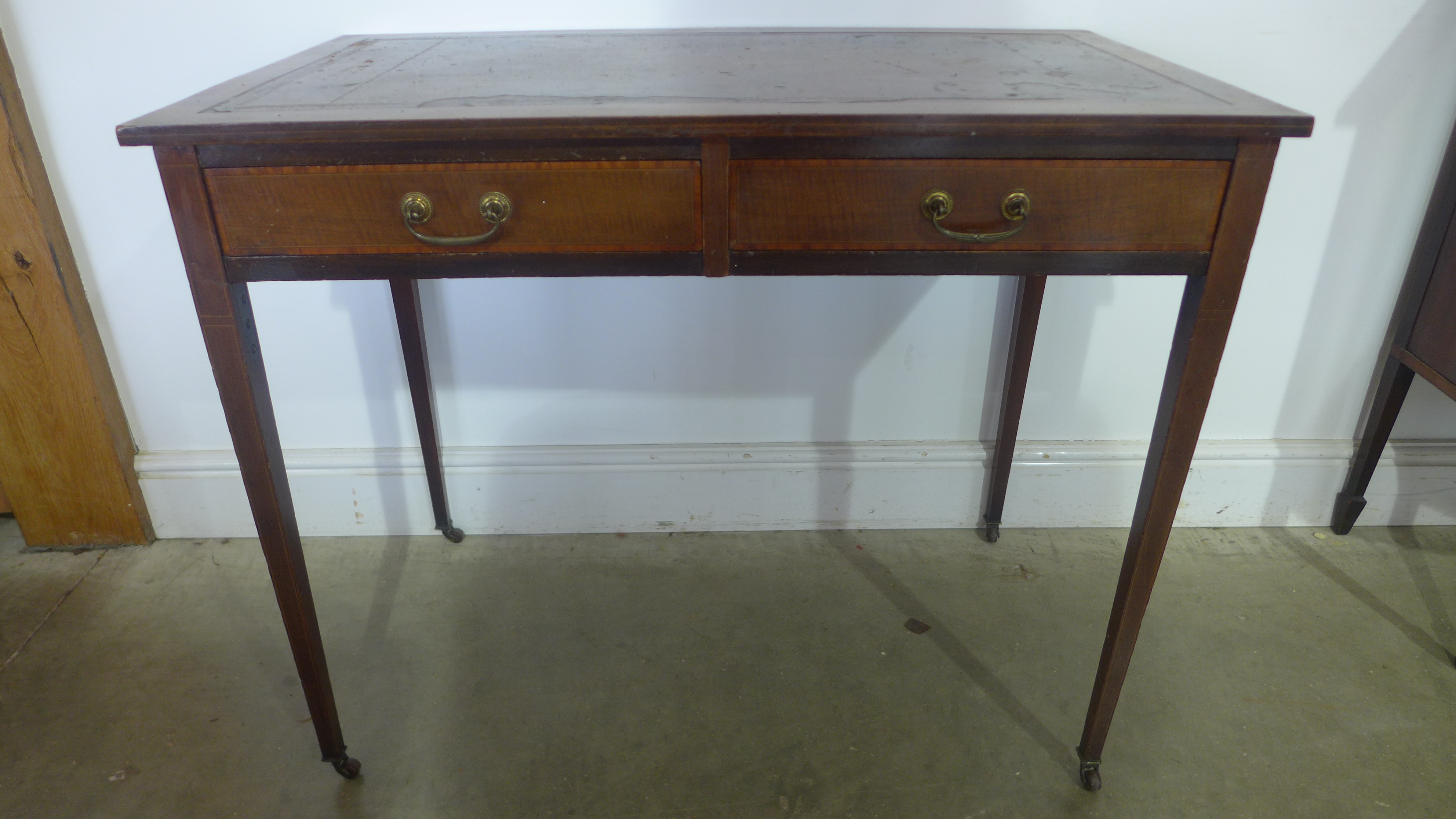A 19th century mahogany writing table with a leather inset top over two drawers on square tapering