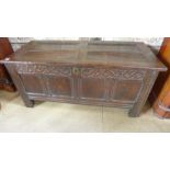 An 18th century oak coffer with a carved panelled front - Height 61cm x 132cm x 58cm