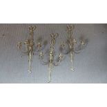 A pair of gilt three branch wall lights with triple candle branches,