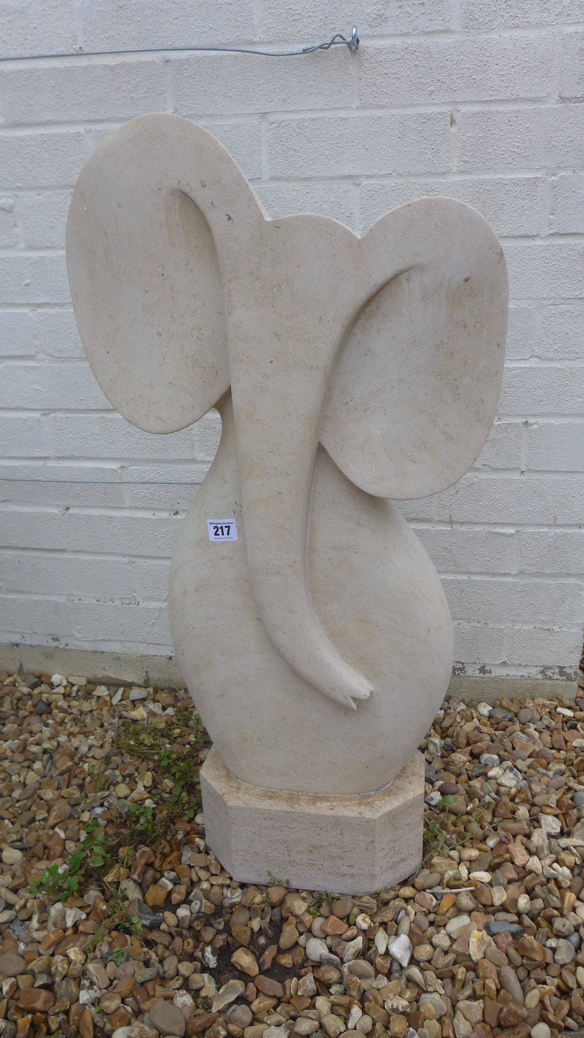 A limestone garden statue of an elephant with an ironstone base - Height 79cm x Width 40cm