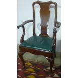 A walnut Georgian style open armchair with green leather seat