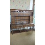 An 18th century oak dresser base with a later rack top the base having three geometric moulded