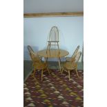 An Ercol golden elm drop leaf table with five single chairs - table height 72cm x 112cm x 123cm -