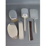 A four piece dressing table silver back set and a pair of hair brushes