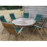 A good quality garden table and six folding teak armchairs with green cushion - approx.