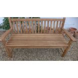 A Bramblecrest teak curved back flat arm three seater bench