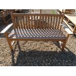 A Bramblecrest teak curved back flat arm three seater bench