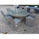 A Bramblecrest Sahara 212cm x 150cm round table with lazy susan and six armchairs,