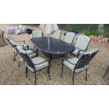 A Bramblecrest oval table with eight armchairs and parasol