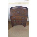 A 1930's carved oak Green Man bureau with three drawers - Height 102cm x 75cm x 40cm