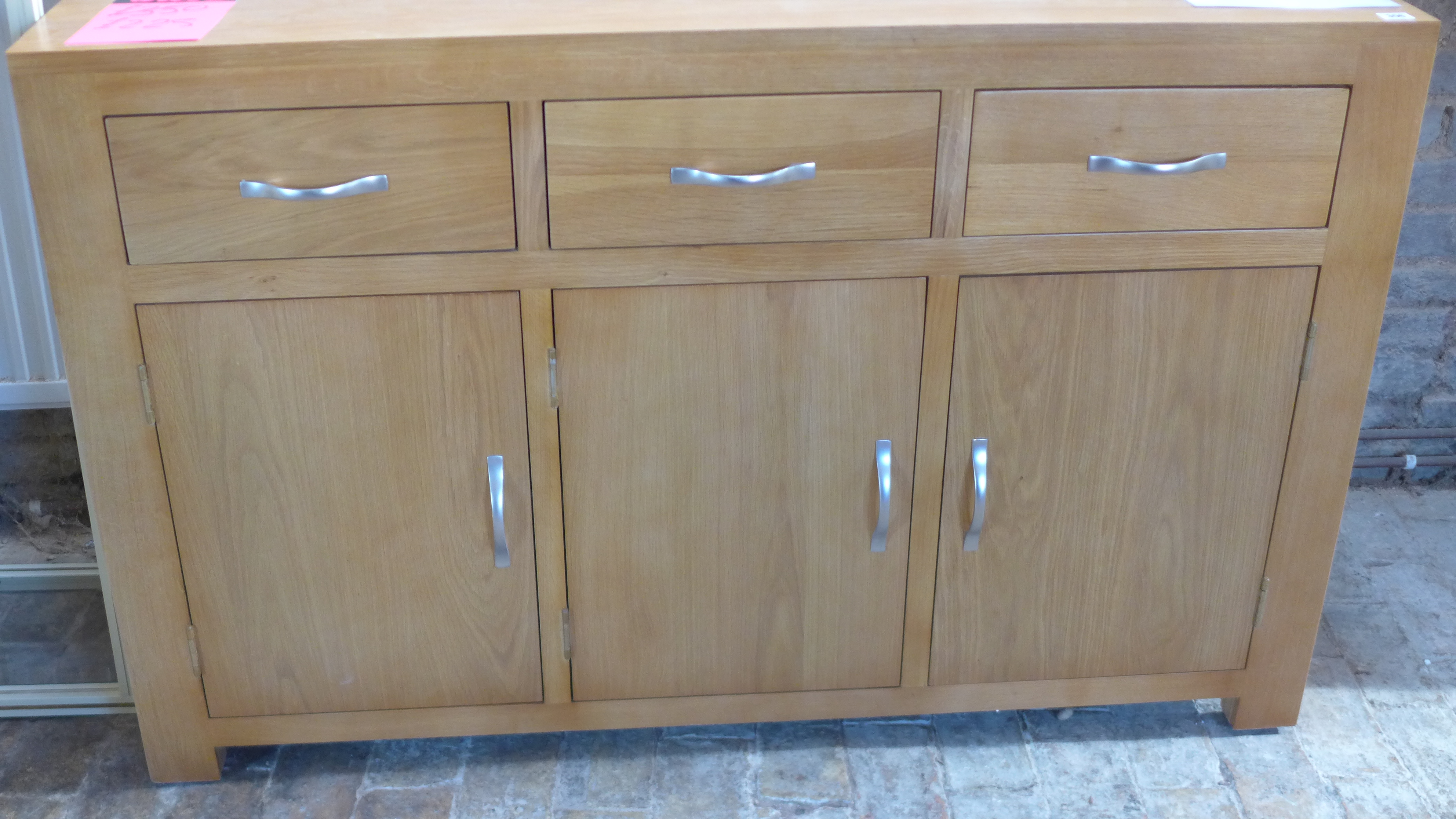 An ex display oak sideboard- with slight warping to top - Width 135cm - as new