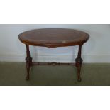 A Victorian burr walnut stretcher table with an oval inlaid top on carved pillar supports united by