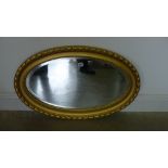 A small oval gilt mirror - 82cm x 52cm