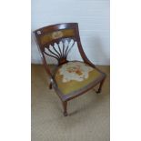 An Edwardian mahogany nursing chair with needlepoint seat