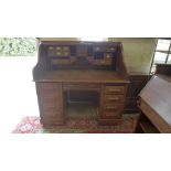 An early 1900s Stewart and Co USA oak roll top desk with a series of small index drawers and pigeon