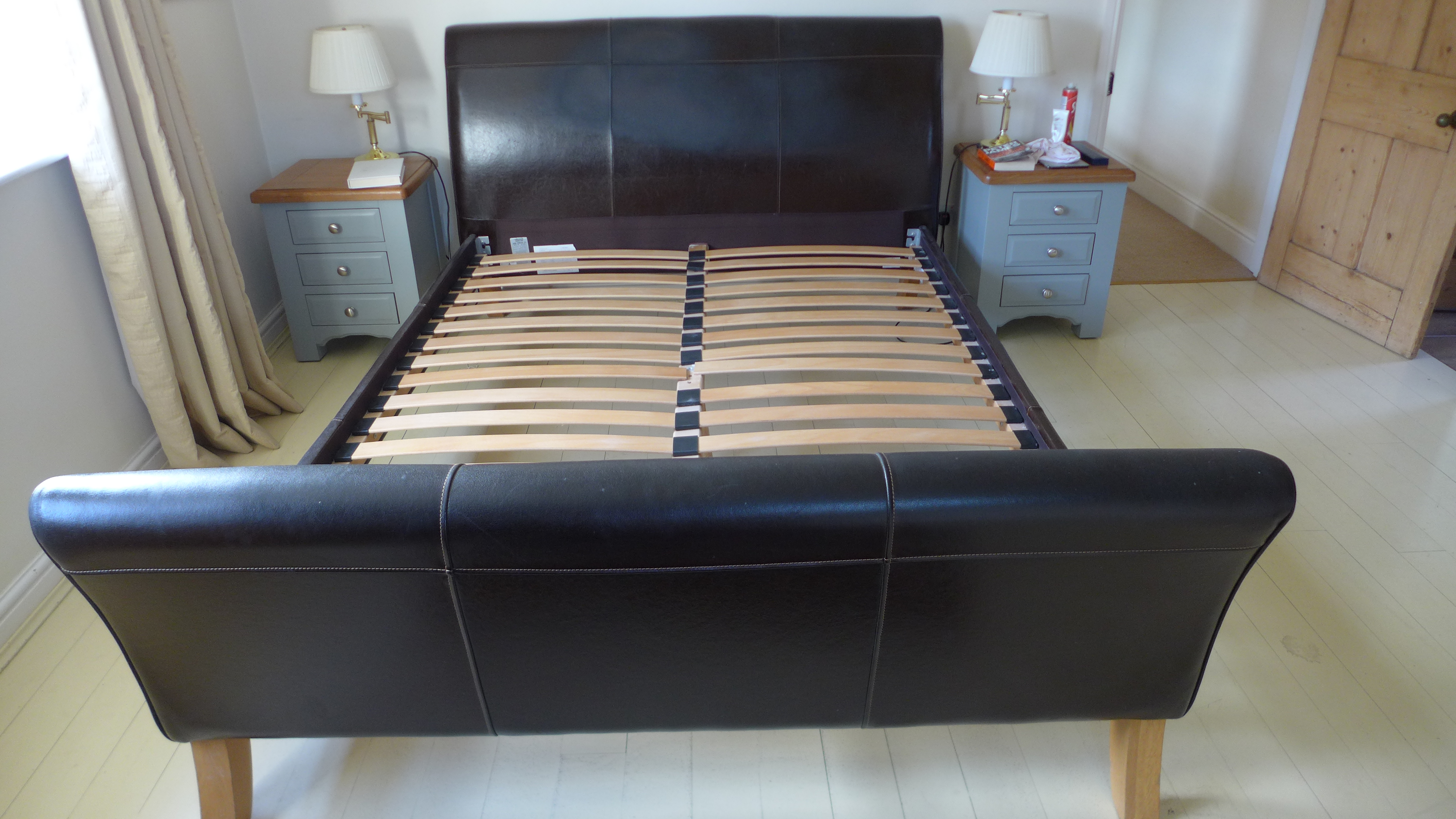 A modern ex John Lewis faux leather bed in good condition - 5ft wide