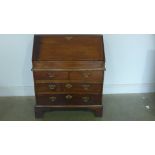 An early George I walnut bureau of small proportions with a fitted interior and well above two