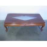 A modern mahogany coffee table with a glass inset top - 138cm x 62cm