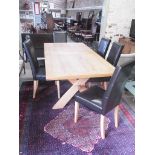 An oak table on X shaped supports with six leather effect chairs - Height 76cm x 210cm x 100cm