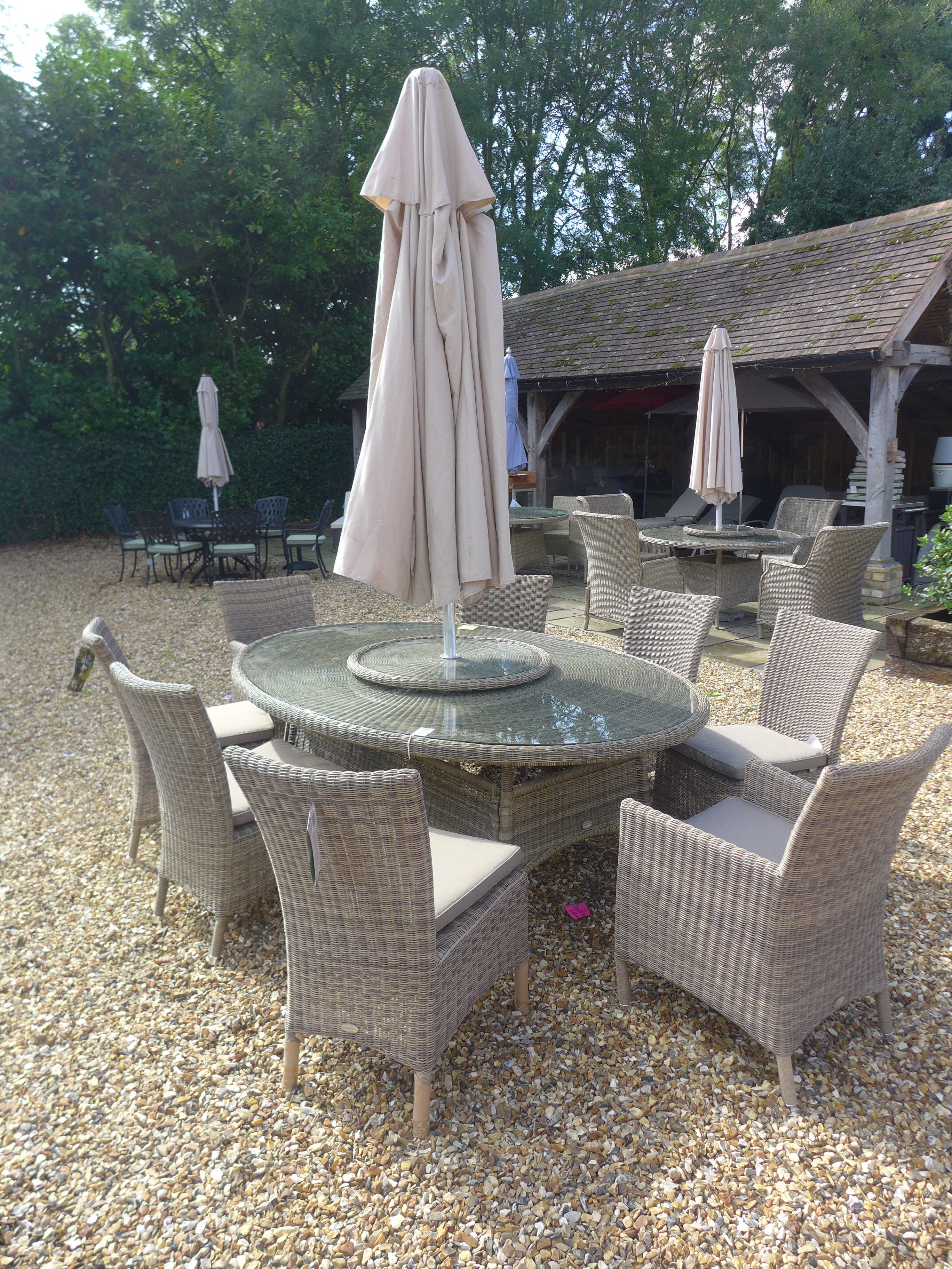 A Bramblecrest Sahara elliptical table (210cm x 145cm) with Lazy Susan, two Foxham armchairs,