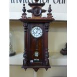 A walnut cased Vienna wall clock with Roman numerals to white enamel dial - height 93cm