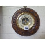 A carved walnut aneroid barometer