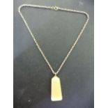 An obelisk shaped stone pendant on a gilt metal chain believed to be 9ct gold