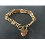 A 9ct yellow gold three bar bracelet with padlock clasp - approx weight 16 grams - in clean
