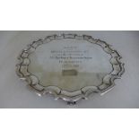 A silver hallmarked salver with piecrust boarder raised on three large scroll feet engraved Bobs
