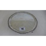 A silver hallmarked salver, ribbed edge with pie crust boarder raised on four pad feet,