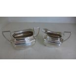 Two silver hallmarked items in the form of a milk jug and sugar bowl,