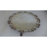 A silver hallmarked salver pie-crust boarder raised on three pad feet marked for London 1926/27 -