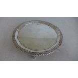 A small silver hallmarked salver or card tray with gadrooned and piecrust boarder raised on three