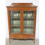 An Edwardian crossbanded mahogany display cabinet with two glazed doors above two drawers - Height
