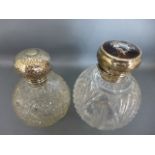 Two silver topped cut glass perfume bottles, one with hammered finish, the other with silver inlaid,