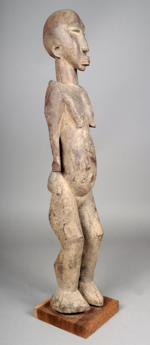 A Lobi standing female figure Burkino Faso 75cm high on a stand.