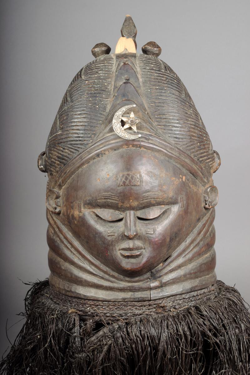 A Mende helmet mask Sierra Leone with a plaited coiffure and ribbed central crest with finials and a