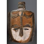 A Nigerian mask with a central crest and scarifications to the forehead and with pigment