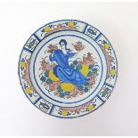 A large Delft polychrome charger  18th century, painted with a central figure of a lady seated on