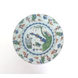 A delftware charger  mid 18th century, painted in blue, red and green with two long-legged birds